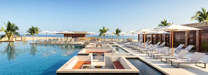 Resort de lujo con alberca infinity y zona de descanso frente al mar en Los Cabos.
